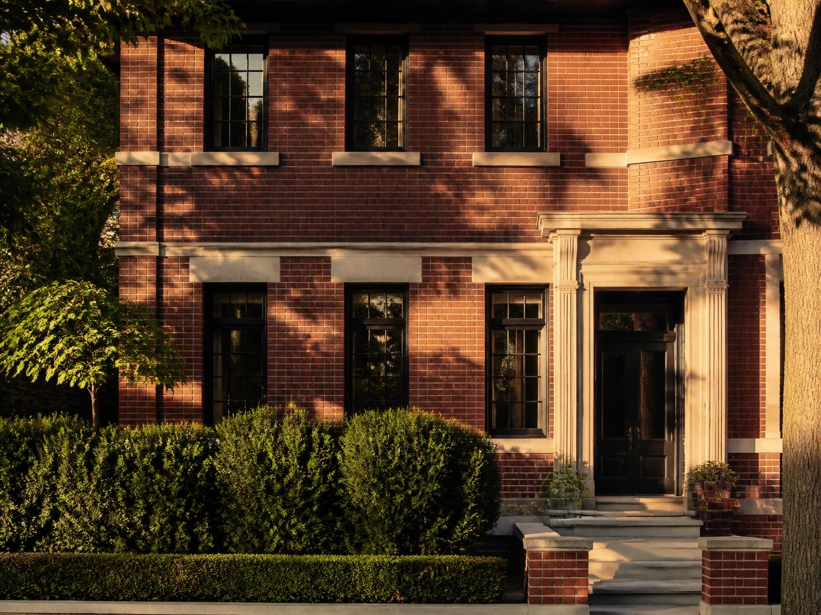 Restored red brick and limestone facade of a Chicago home at golden hour